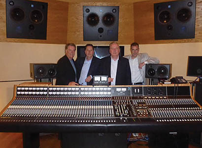 Pictured from left to right: Dan Zimbelman, API Director of Sales; Steve Angel, Source/HHB Director of Sales; Ian Jones, Source/HHB Managing Director; and Gordon Smart, API Managing Director posing behind the vintage API Legacy console at British Grove Studios, owned by Mark Knopfler.