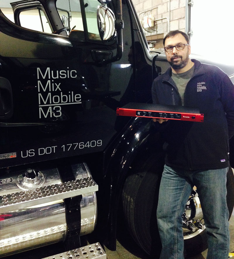 Joel Singer, outside the Music Mix Mobile M3 recording rig, holds a Focusrite RedNet 6 MADI Bridge recently added to their recording arsenal.