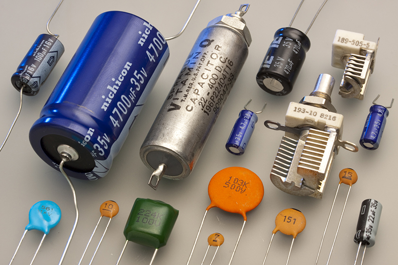 A simple capacitor is two conducting plates parallel to each other separated by an empty space in between. Because of how the universe is built, an electric field can pass between the two plates.